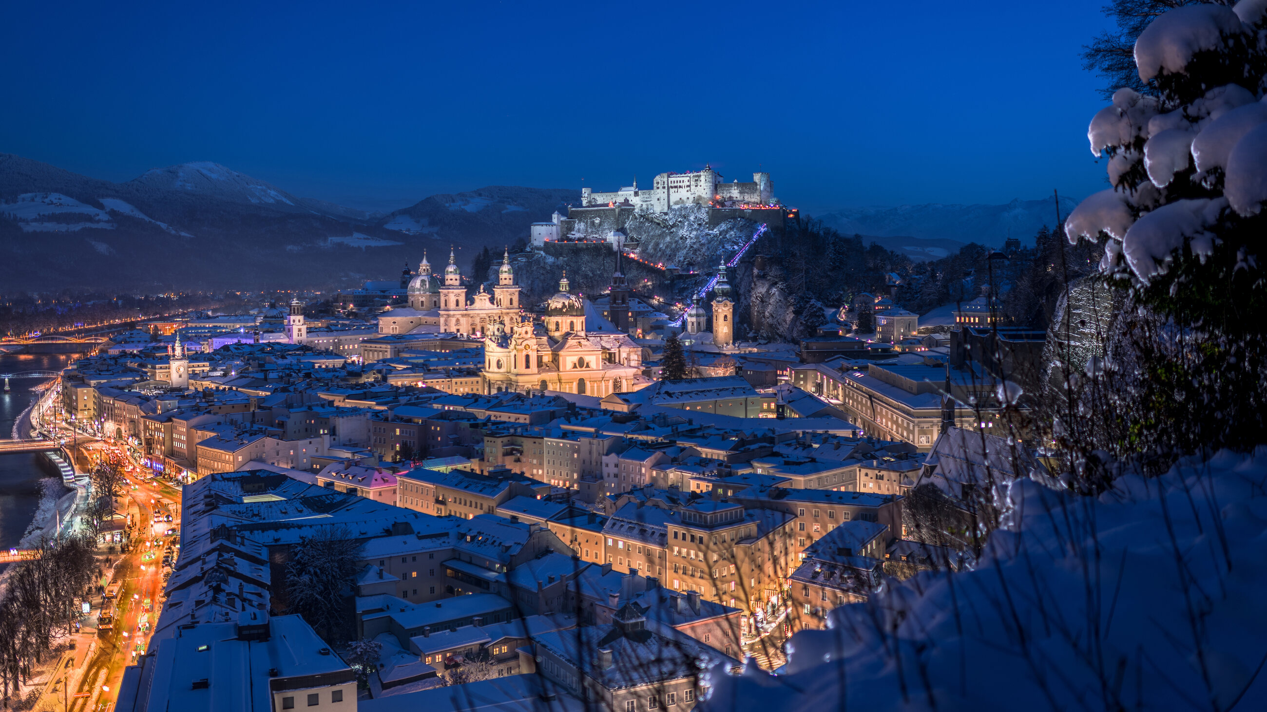 Verschneites Salzburg und Festung Hohensalzburg bei Nacht